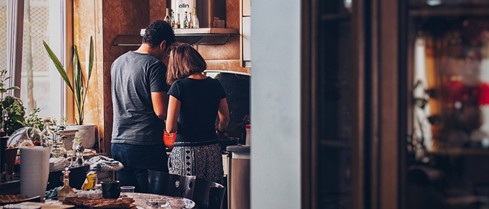 Couple cooking a meal together in a warm kitchen